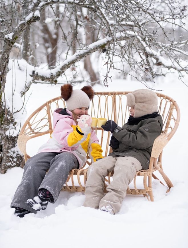 Lapset talvimaisemassa Lumikenkä sohvassa istumassa