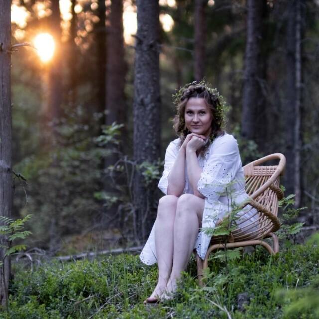 Nainen istuu metsässä Simpukka tuolissa